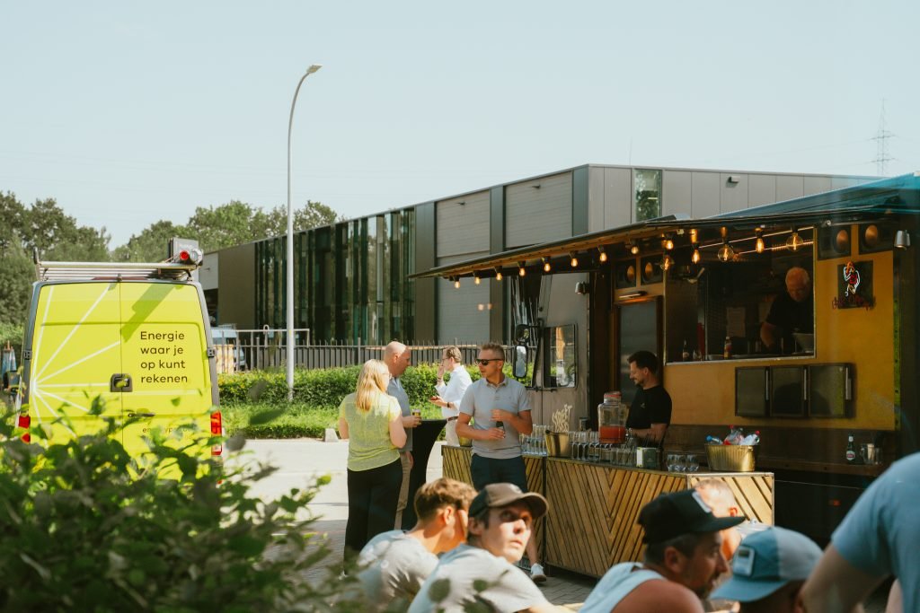 Bezoekers vieren de lancering van het EnergyPro-merk tijdens een evenement met foodtruck, netwerkmomenten en informele gesprekken.